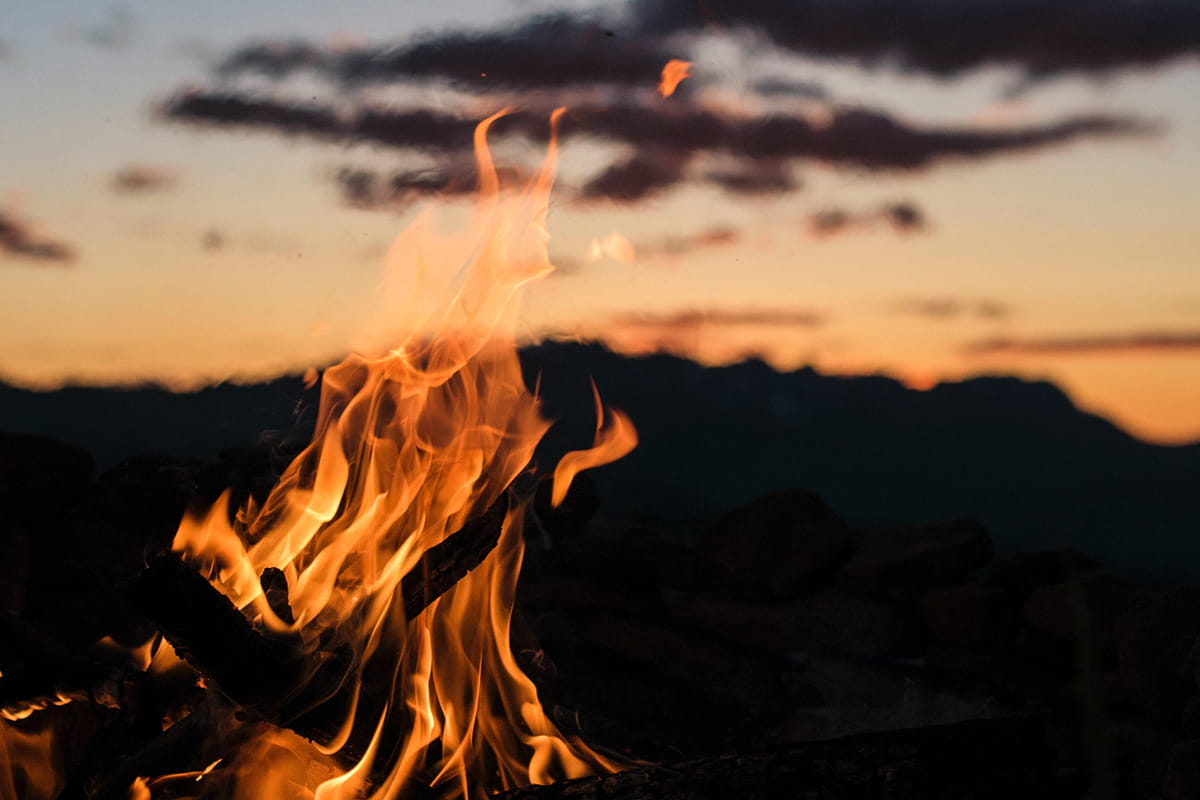 Campfire by the lake at sunset in fall