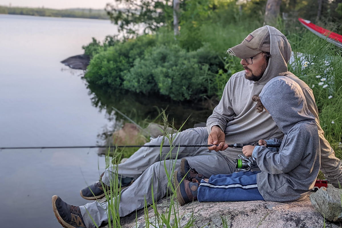 A father and son fishing on the lake in fall